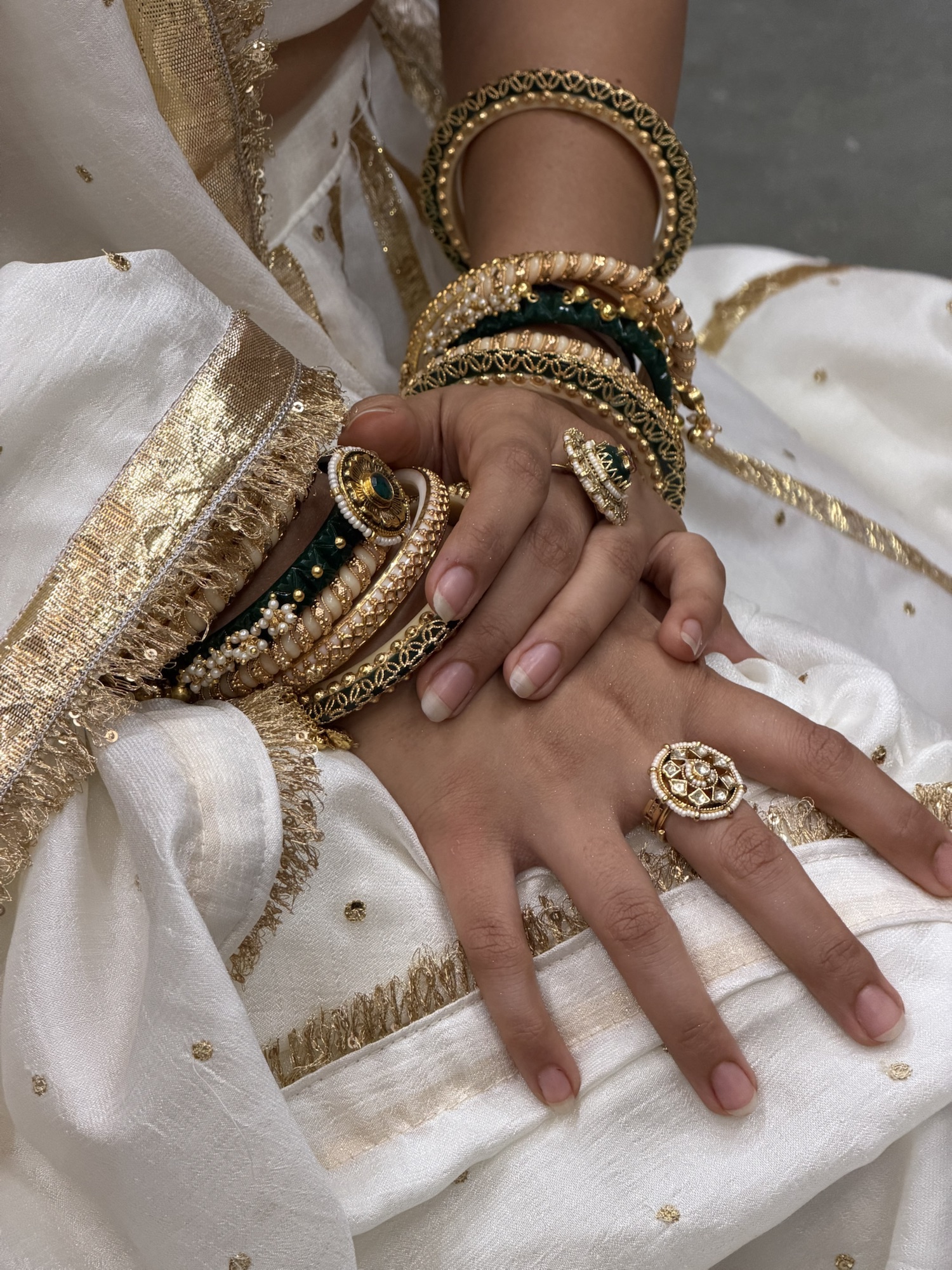 Emerald and ivory bangles styled with two statement rings